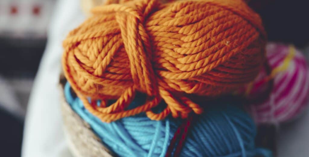 1120×800-merino-hw20-blog-3 Close up of orange and blue yarn ball to do knit work hobby. Natural wool merino or alpaca